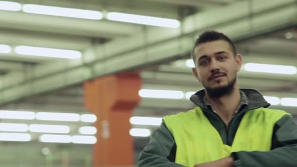 Porträt eines Mannes, der in einer Logistikanlage beschäftigt ist und in die Kamera lächelt - Filmmaterial, Video