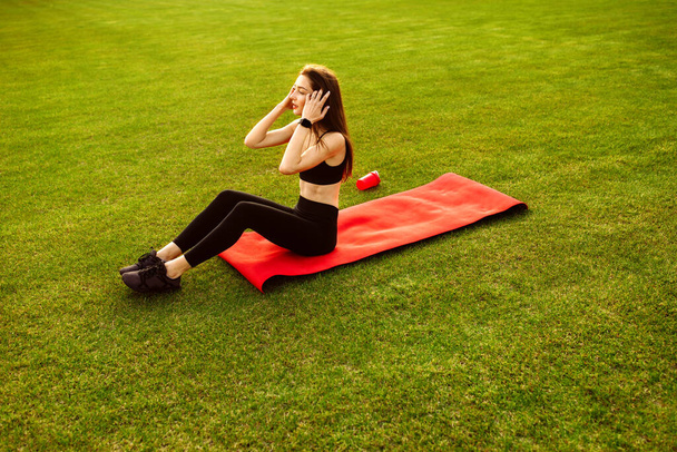 young woman relaxing after workout in the park - Foto, Bild