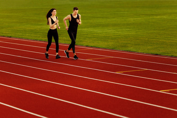 two young athletes running on the stadium - Photo, Image