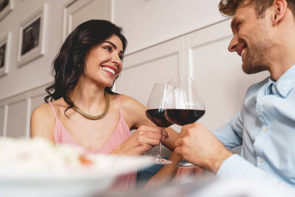 Beautiful young couple toasting with wine in cafe - Foto, Bild