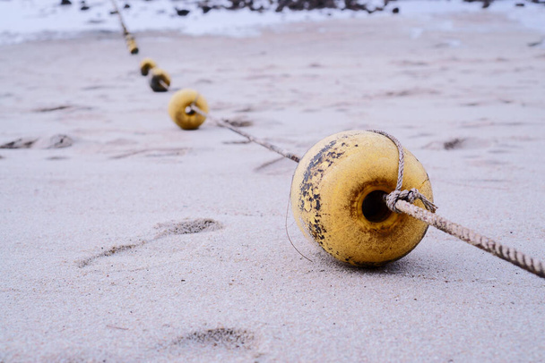 Sarı şamandıralar sahilde iple bağlandı. - Fotoğraf, Görsel