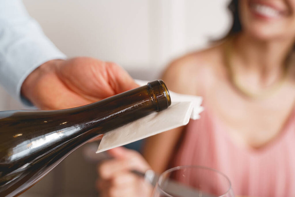 Waiter serving wine to young woman in restaurant - Foto, Imagen