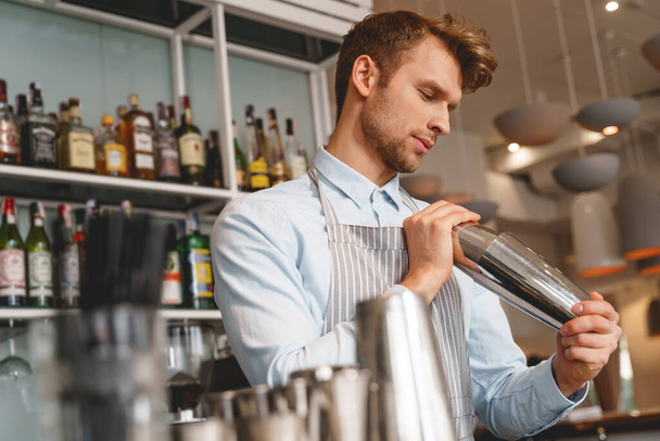 Handsome bartender in apron making drink at work - Fotoğraf, Görsel