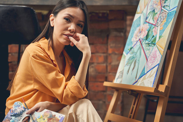 Приваблива молода леді живопис картина в домашній художній студії
 - Фото, зображення