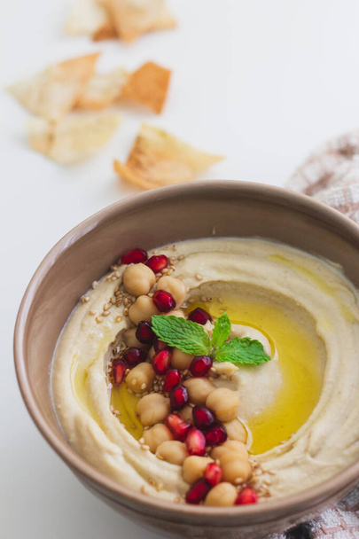 Hummus Dip casero cubierto con semillas de granada
 - Foto, imagen