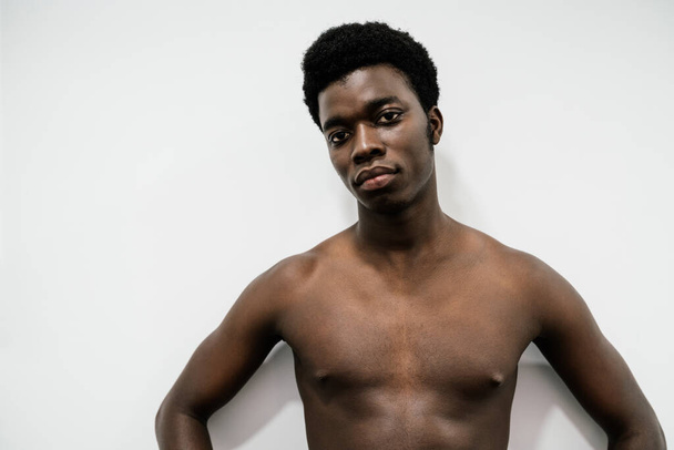 Ritratto di un uomo africano muscoloso in posa in uno studio fotografico con sfondo bianco nudo senza maglietta
 - Foto, immagini