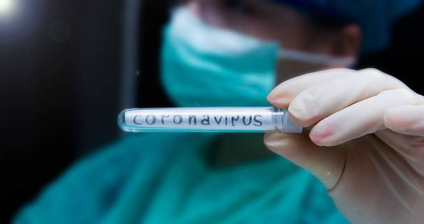 hand in glove holding medical test tube with blood positive on covid19 , pandemic concept of prevention of contamination coronavirus  - 写真・画像