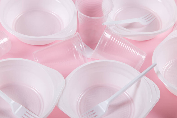 Plastic utensils on pink background. Not environmental, pollution. - Foto, imagen