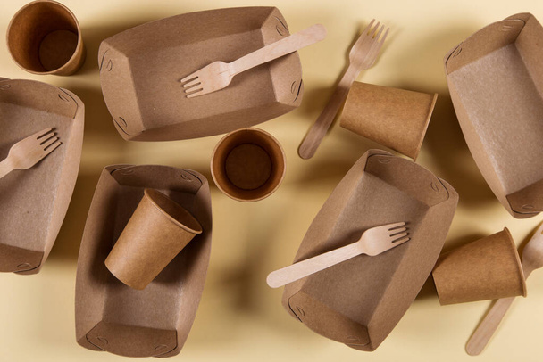 Paper eco-friendly utensils, without contamination, for reprocessing, brown on yellow background. - Foto, Imagem