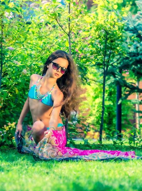 Model looking Girl standing in a swimsuit on the background of green grass and forest. - Foto, Imagem
