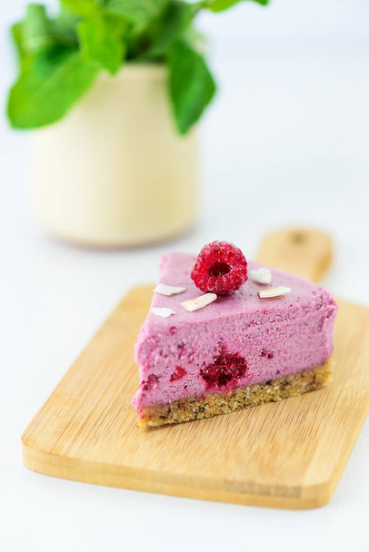 Slice of homemade raw cashew cake with raspberries, mint and lime on a light table. Vegan dessert, sugar free, gluten, lactose. - Foto, Imagen