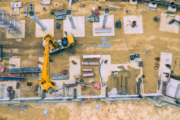 Plac budowy z góry. Widok z lotu ptaka miejsc pracy w sprzęcie budowlanym, pracownicy z ciężkimi maszynami. Przemysłowy widok z góry wykonany przez drona.  - Zdjęcie, obraz