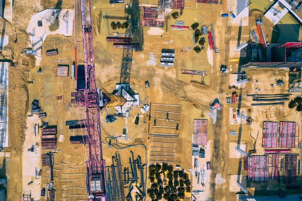Plac budowy z góry. Widok z lotu ptaka miejsc pracy w sprzęcie budowlanym, pracownicy z ciężkimi maszynami. Przemysłowy widok z góry wykonany przez drona.  - Zdjęcie, obraz