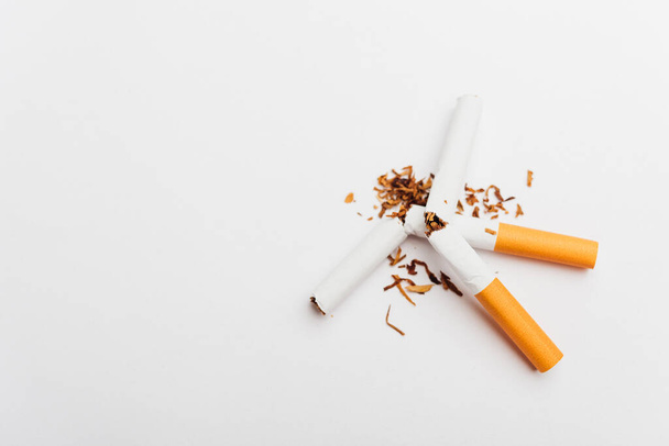 31 May of World No Tobacco Day, no smoking, close up of broken pile cigarette or tobacco STOP symbolic on white background with copy space, and Warning lung health concept - Фото, изображение