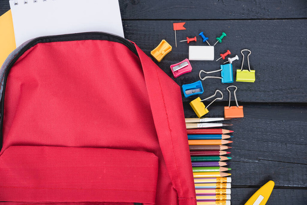 Top view Red bag backpack for education children on black wooden  background back to school concept - Fotoğraf, Görsel