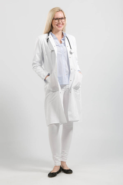 μια νεαρή φιλική γυναίκα γιατρός στο γενικό και στηθοσκόπιο του γιατρού - Φωτογραφία, εικόνα