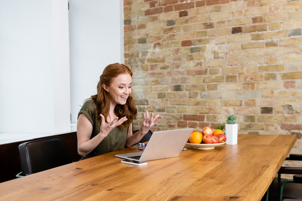 Lachend telewerker gebaar tijdens sollicitatiegesprek op laptop thuis  - Foto, afbeelding