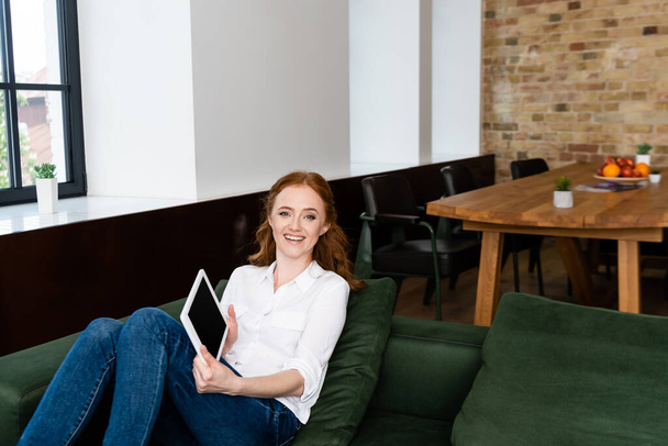 Belle femme souriante montrant tablette numérique avec écran blanc à la maison
  - Photo, image