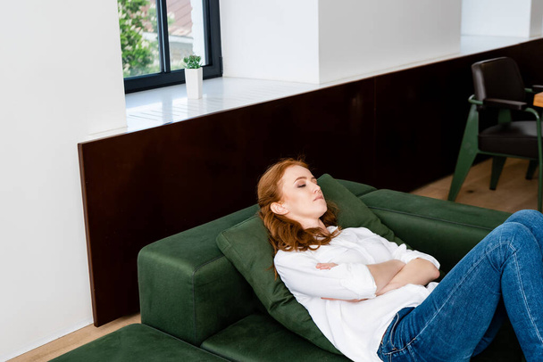 Depressed woman with crossed arms lying on couch  - Photo, Image