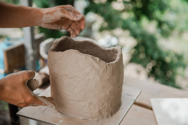 Man makes pottery clay dishes with blurry background - Photo, image