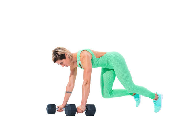 woman doing plank exercise on dumbbells isolated over white background - Foto, afbeelding