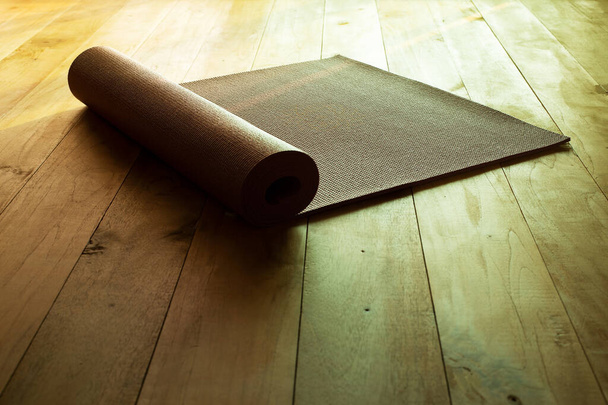 Yogamatte auf Naturholzboden mit Sonnenlicht Entspannung Wellness Aktivität Sport zu Hause bleiben  - Foto, Bild