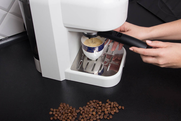 nő csinál espresso fehér eszpresszó kávéfőző gép fehér és fekete konyha. - Fotó, kép