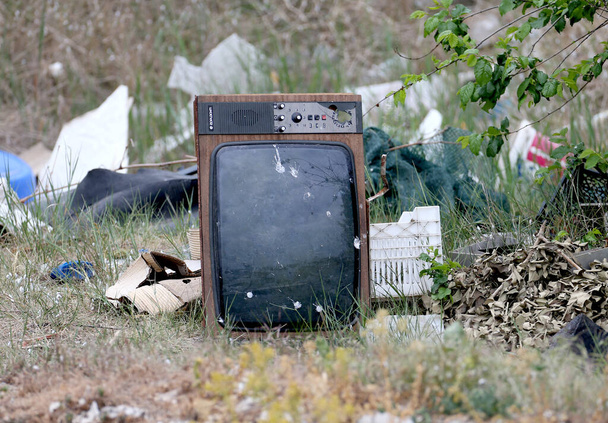 Old Soviet TV "Horizon" thrown into a landfill. The device lies alone on the ground surrounded by other debris. Symbolic frame - Photo, Image