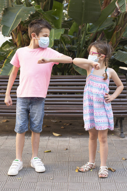 Kinderen begroeten elkaar tijdens de coronaviruspandemie - Foto, afbeelding