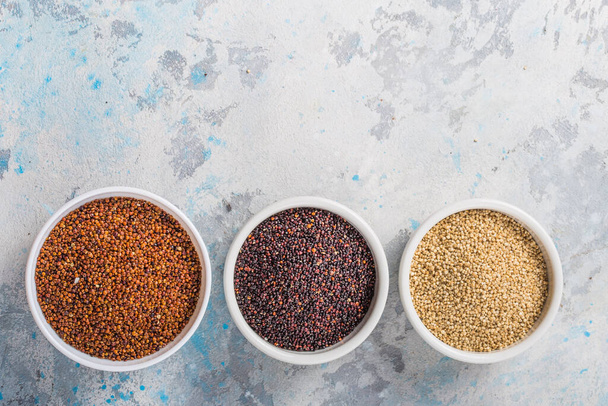 Black, red and white quinoa grains in a plate on white background. Gluten free Healthy food. Chenopodium quinoa closeup - Zdjęcie, obraz