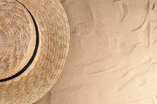 Composición vacaciones de verano. Sombrero sobre fondo de arena con una copia del espacio. Fondo de verano
. - Foto, Imagen