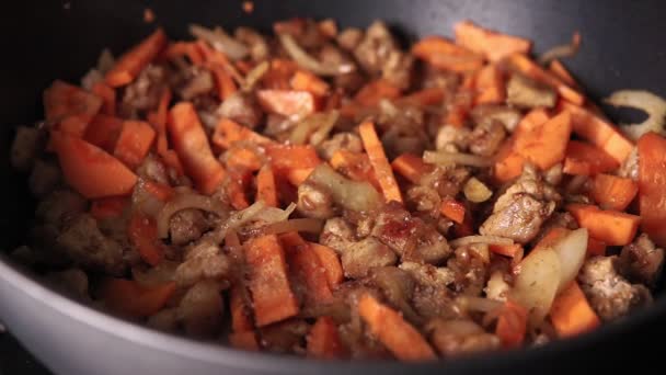 stukjes vlees en groenten worden gebakken in een koekenpan. thuis koken - Video