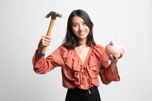 Asian woman with pig coin bank and hammer on white background - Fotografie, Obrázek
