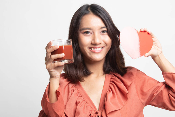 Young Asian woman with tomato juice and red heart on white background - Foto, Bild