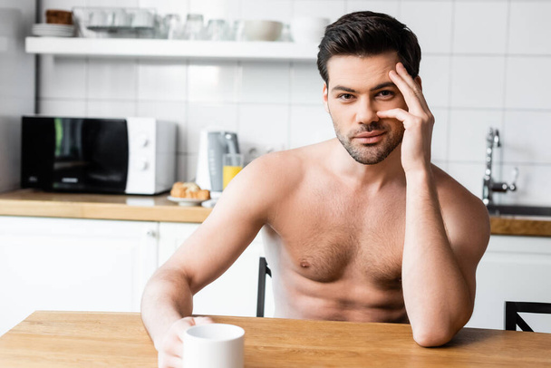 handsome sexy shirtless man holding cup of coffee on kitchen in morning - Valokuva, kuva