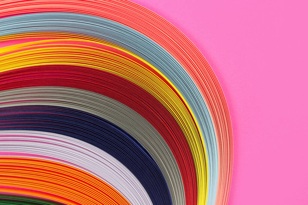 Colorful quilling, twisting paper, abstract rainbow on pink background - Photo, Image