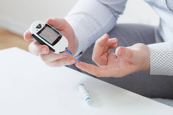 person measures blood sugar with glucometer - 写真・画像