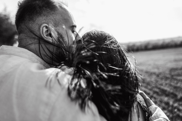 Close up kissing portrait of coule. Love story outdoor in spring field. Loving couple hugging and walking.  - Photo, Image
