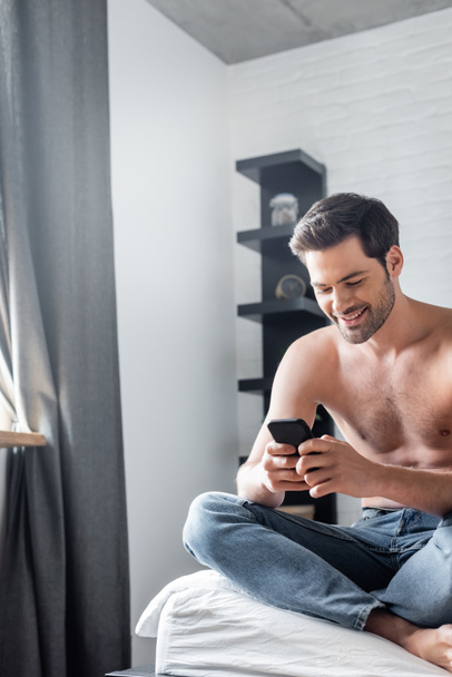 happy sexy man using smartphone on bed at home - Foto, Imagem