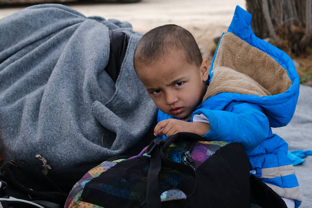 Πρόσφυγες και μετανάστες περιμένουν να μεταφερθούν στο λιμάνι της Μυτιλήνης από το χωριό Σκάλα Σικαμιάς, στο νησί της Λέσβου, 4 Μαρτίου 2020. - Φωτογραφία, εικόνα