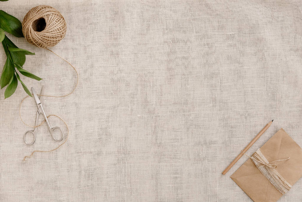 Ножницы, шпагат, винтажная эмаль на коричневом белье - в домашней ателье. Пространство для макета дизайна
 - Фото, изображение