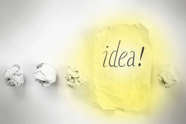fila de bolas de papel con hoja de papel e inscripción "idea!" en él. concepto de creación
 - Foto, imagen