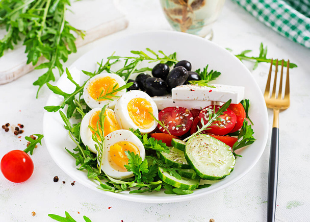 Kahvaltıda. Yunan salatası ve haşlanmış yumurta. Taze sebze salatası, domates, salatalık, zeytin, roka ve peynir. Eğilim gıdası. - Fotoğraf, Görsel