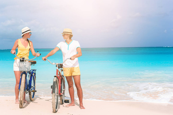 счастливая семья катается на велосипедах на пляже
 - Фото, изображение