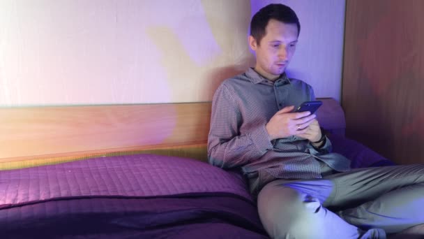 A man at home sits in a phone and plays in an online casino, emotions from the win - Filmati, video