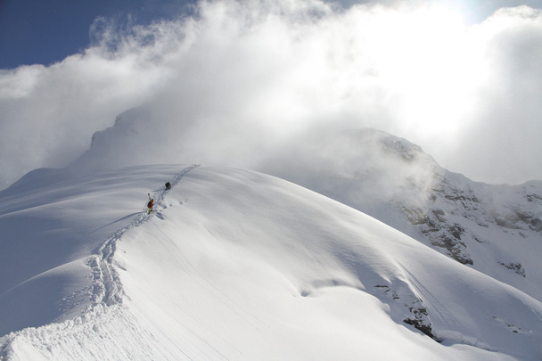 Skiers climbing a snowy mountain - Фото, изображение