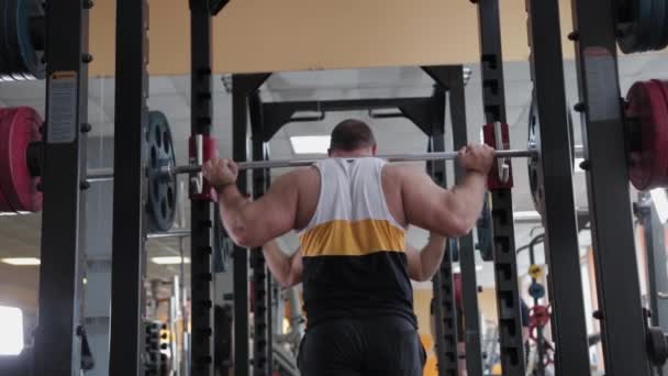 Big and powerful weightlifter crouches with a heavy barbell. - Záběry, video