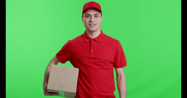 Cheerful courier with parcel gesturing thumb up - Metraje, vídeo