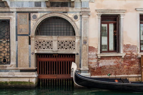 Velencei csatorna, gondola egy gyönyörű fal mellett - Fotó, kép