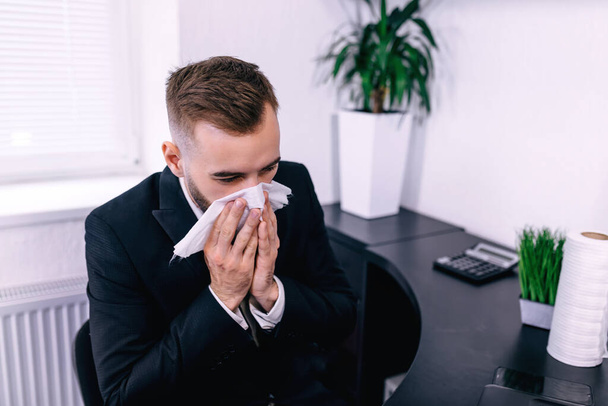 sick entrepreneur blowing in a wipe at office feeling sick and tired - Photo, Image